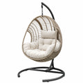 Poltrona sospesa oscillante 105 × 105 × 195 cm in rattan sintetico beige con cuscini crema e supporto nero